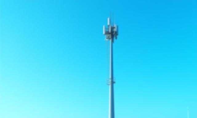 A modern 5G cellular tower against a clear sky, symbolizing advanced connectivity.